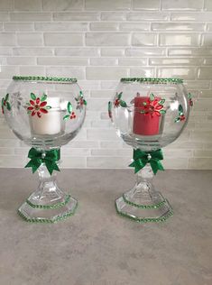 two glass bowls with candles in them on a table