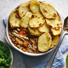 a white bowl filled with soup next to some broccoli and other food items