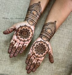 two hands with henna tattoos on them