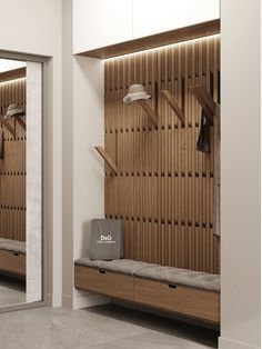 a wooden bench sitting in front of a mirror next to a wall mounted coat rack