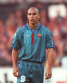 a soccer player is standing on the field with his head turned to look like he's about to kick the ball