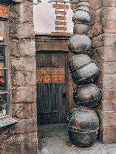 an old building with large metal pots in front of it and a sign on the door