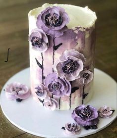 a cake decorated with purple flowers on a white plate