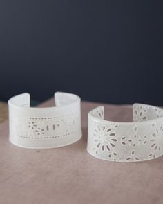 two white bracelets sitting on top of a table