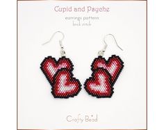 a pair of red heart shaped beaded earrings on top of a white card with the words cupid and dysjeche