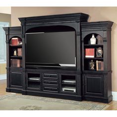 a large entertainment center with bookshelves and a flat screen tv mounted on the wall