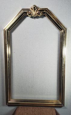 an ornate gold frame on top of a wicker mat