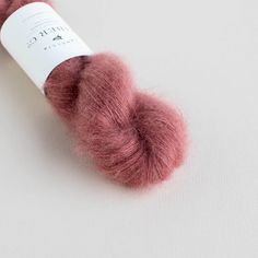 a skein of pink wool sitting on top of a white surface