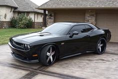 a black sports car parked in front of a house