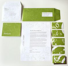 an assortment of stationery items displayed on a white surface with green and white designs