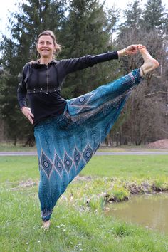 a woman standing in the grass with her legs spread out and wearing a blue skirt