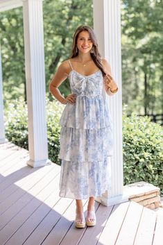 Light blue floral print layer tiered midi dress with decorative bow on bodice You will feel just like a princess in this Sweet Florals Blue Midi Dress! She's so delicate, and pretty with white and light blue floral print, large bow on the ruched bodice, and layer tiered skirt. The perfect Summer dress for all of your upcoming celebrations - from Wedding events to summer vacations and everything in between! Fits true to size; flowy skirt Model is 5'5" wearing a small Fabric contains slight stretc Bridgerton Dresses, Cruise Dresses, Wedding Event Dresses, Cruise Dress, Skirt Model, Purple Midi Dress, Event Dress, Summer Vacations, Graphic Tee Dress