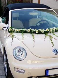 a white car with flowers on the hood