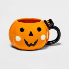 a ceramic mug with a pumpkin face on it