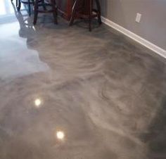 a kitchen with gray floors and white walls