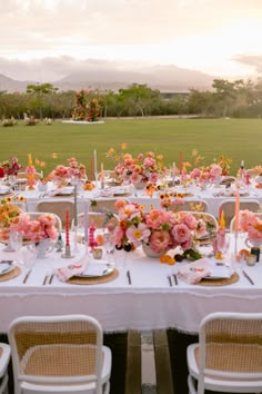 a table set up with flowers and candles for an outdoor wedding reception in the mountains