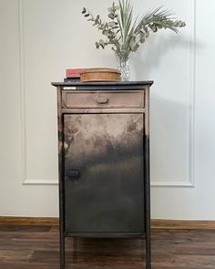 an old metal cabinet with a potted plant on top