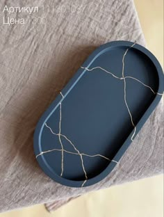 a blue tray sitting on top of a table next to a gray cloth covered pillow