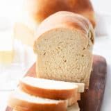 sliced loaf of bread sitting on top of a wooden cutting board