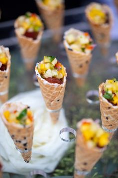 there are many ice cream cones with different toppings on top of each cone,