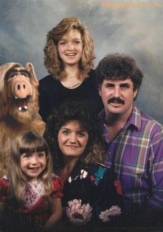 the family is posing for a photo with their dog