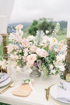 the table is set with white and pink flowers