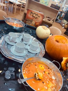 the table is full of soup and pumpkins