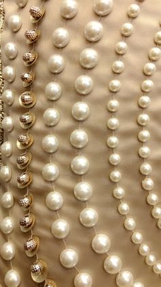 pearls and other jewelry are hanging on a wall