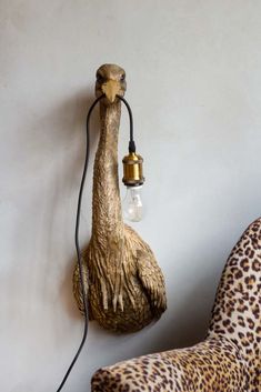 a lamp that is on the wall next to a leopard print chair and foot rest