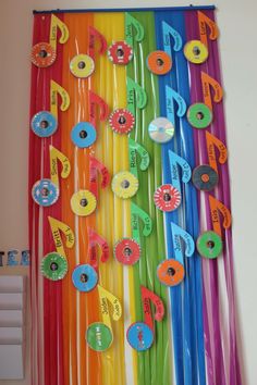 colorful streamers are hanging on the wall in front of a bulletin board with music notes