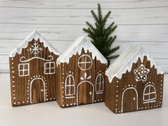 three wooden houses with white frosting on them