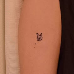 a small butterfly tattoo on the right arm and leg, with stars in the background