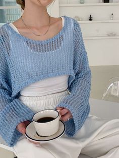 a woman holding a cup of coffee in her hands