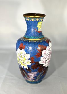 a blue vase with flowers painted on it