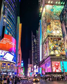 a busy city street at night with tall buildings and neon signs on the side of it