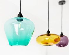 three different colored glass lights hanging from the ceiling