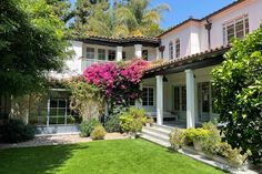 a large house with lots of flowers in the front yard