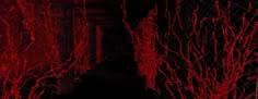 the dark hallway is covered in red paint and spooky branches are growing on the walls