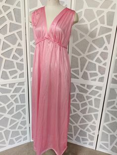 This is a sweet v neck sleeveless satin nylon nightgown with a plaited tie under the bust and ties at the back. It is new old stock with tags by Jillray made in Australia in the 60s or 70s. It is a long below knee length  Condition is very good  Bust 96cm Length shoulder to hem 142cm Beautiful Nightgown, Womens Nightgowns, Women's Nightgowns, Pajama Robe, Plaits, Pink Peach, Nightgowns, The 60s, Tie Belt