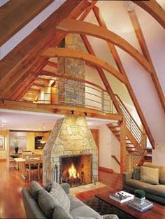 a living room filled with furniture and a fire place in the middle of a loft