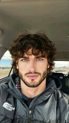 a man sitting in the back seat of a car looking at the camera with a serious look on his face