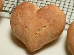 four heart shaped loaves on a cooling rack