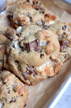 chocolate chip cookies with marshmallows on top are sitting in a tin foil container