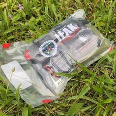 an empty water bottle laying on the ground in the grass with its contents wrapped around it