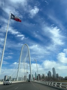 an american flag flying over the top of a bridge