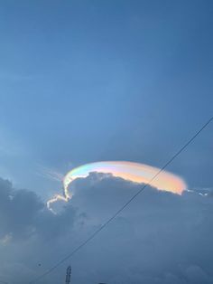 a rainbow in the sky above some power lines