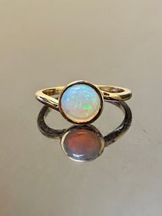 DeKara Designs Collection Our latest design! An Elegant and Lustrous Round Australian Opal Solitaire Engagement Ring. Metal- 14K Yellow Gold, .583. Stones- Round Australian Opal 6 MM. Latest of my creations! A Timeless Handmade Solitaire Opal Engagement Ring Made in 14K Yellow Gold. This ring features a fiery round Australian opal that is professionally and securely bezel set. The ring is made in solid 18K yellow gold. This is a timeless solitaire ring that has a modern twist. Size- 3-13 Please Opal Ring Bezel Set, Solitaire Opal Ring, Antique Opal Ring, Gold Opal Engagement Ring, Engagement Ring Modern, 14k Gold Opal Ring, Opal Solitaire Ring, Opal Wedding Ring, Diamond Circle Pendant