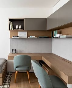 a bedroom with a bed, desk and chair in it next to a wall mounted bookshelf