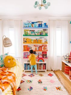 a child's bedroom with colorful bookshelves and toys