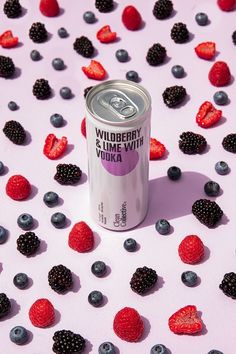 a can of wildberry and blackberries yogurt with berries scattered around it